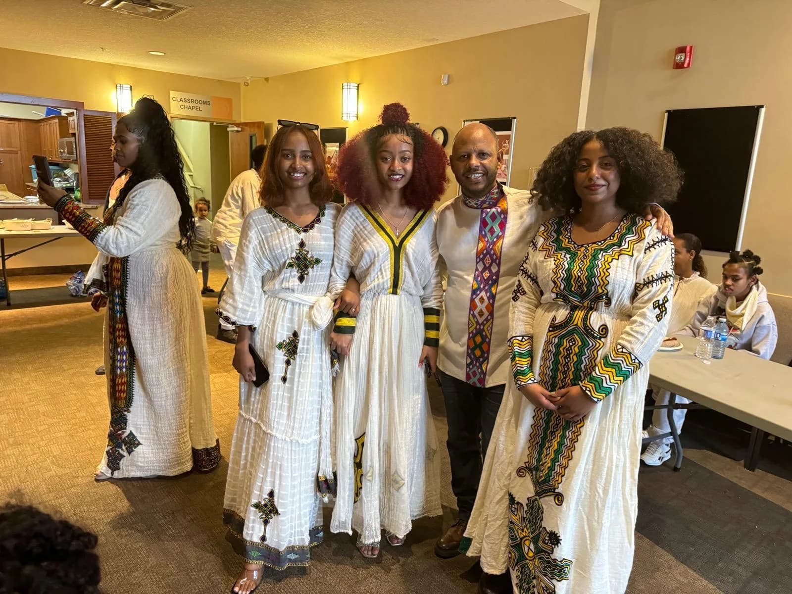 Friends in traditional dress smiling together at an Ebenezer Relief Society celebration